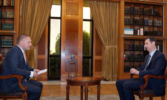 Syria's President Bashar al-Assad (R) speaks during an interview with Russian state television RU24 in Damascus.