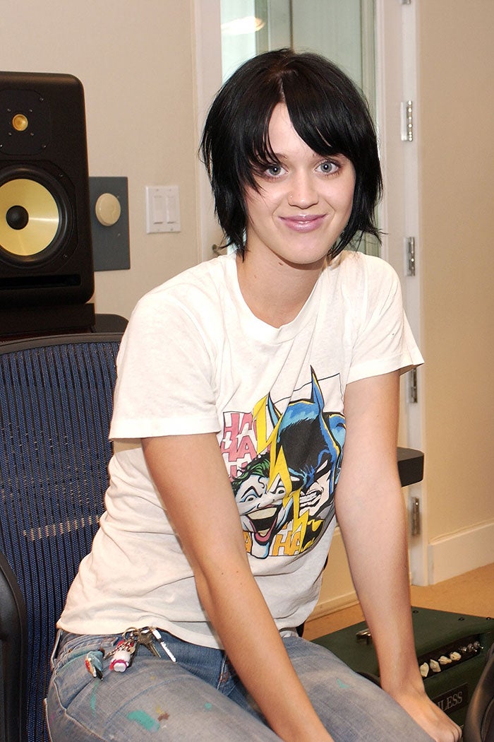 A white woman with dark hair wears a white T-shirt and smiles.