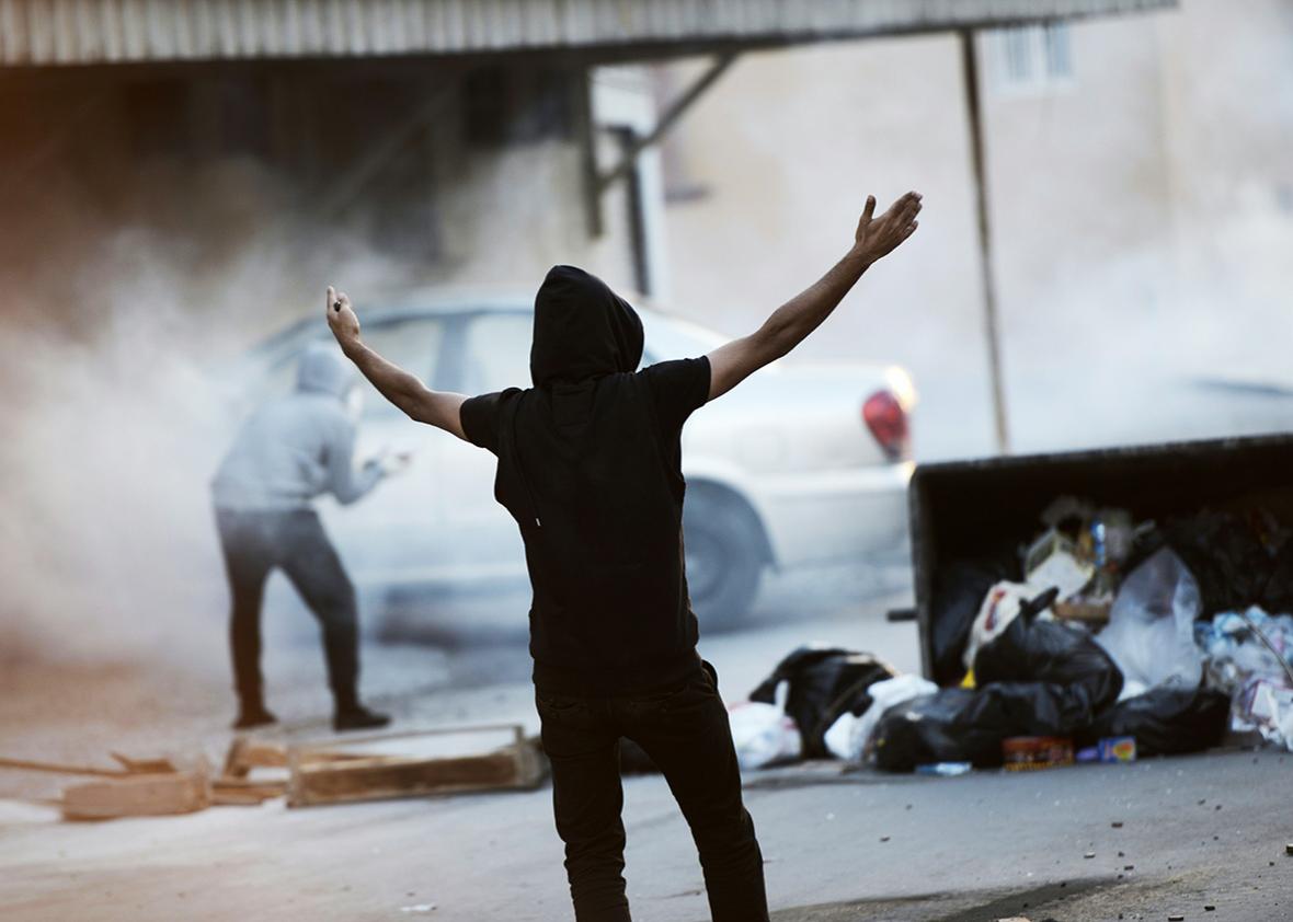 A Bahraini protester shouts slogans during clashes with riot police following a demonstration to mark the fifth anniversary of the Arab Spring-inspired uprising, on February 12, 2016, in the mainly Shiite village of Sitra, south of Manama. 