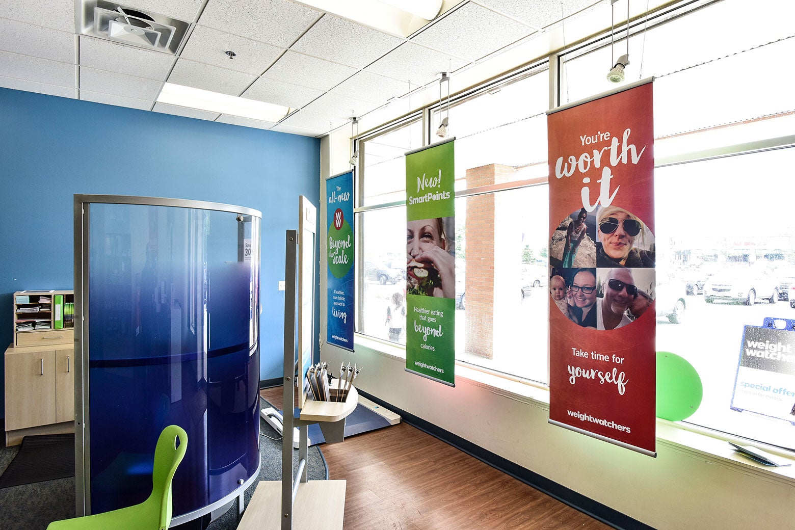 Signs like "You're worth it!" are displayed in a WeightWatchers meeting room.