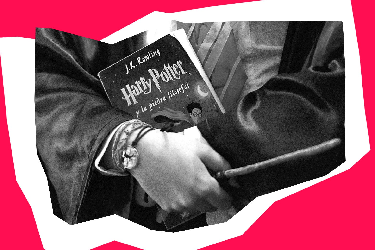 A boy clasping a Harry Potter book and a magic wand to his chest