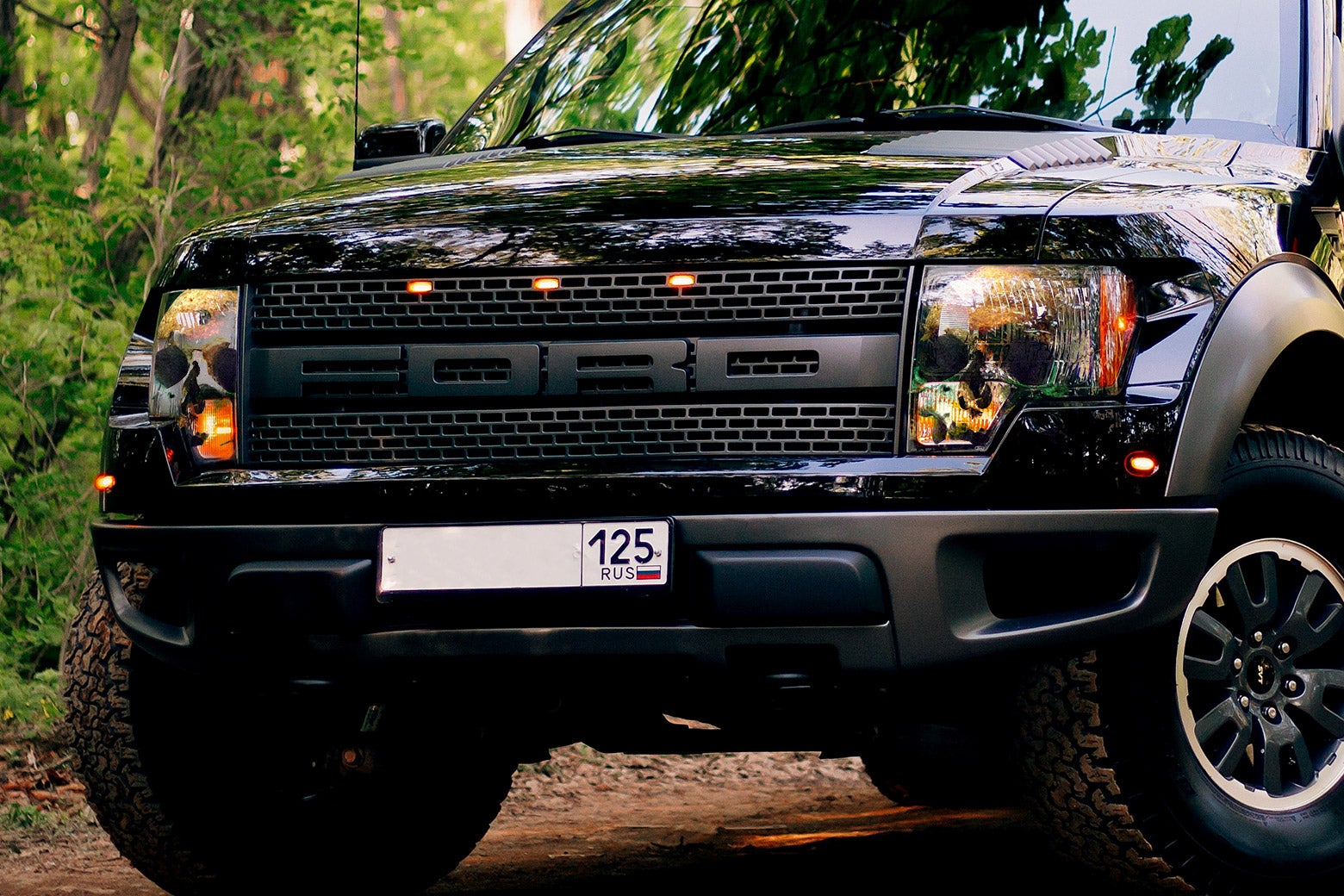A close-up of a black Ford F-150 with skulls in the headlights.
