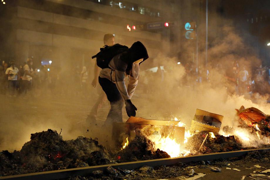 A supporter of opposition leader Leopoldo Lopez sets fire to a barricade during a protest against Nicolas Maduro's government in Caracas February 19, 2014. 