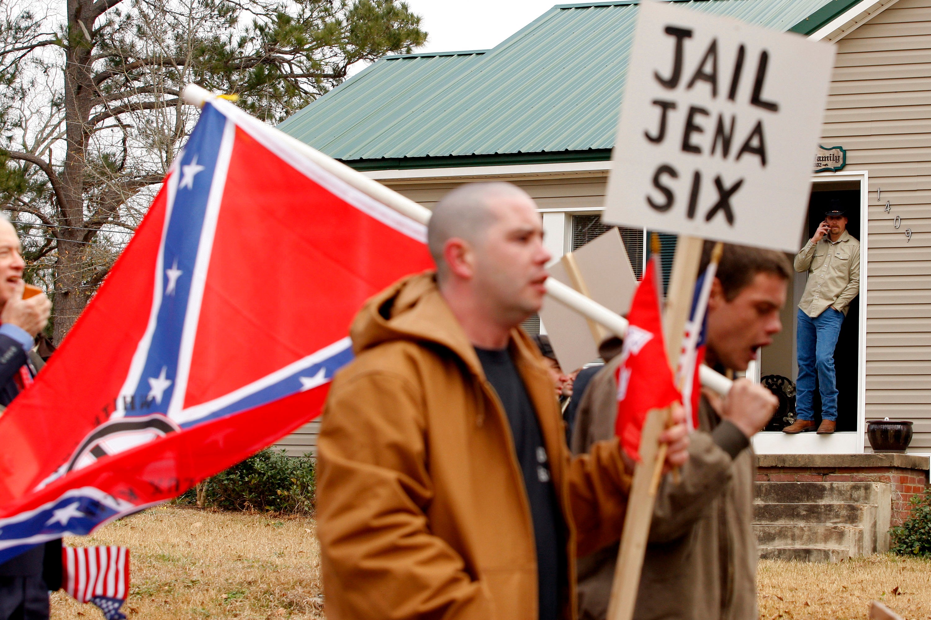 A group of men carrying the Confederate flag and a sign that reads "Jail Jena Six."