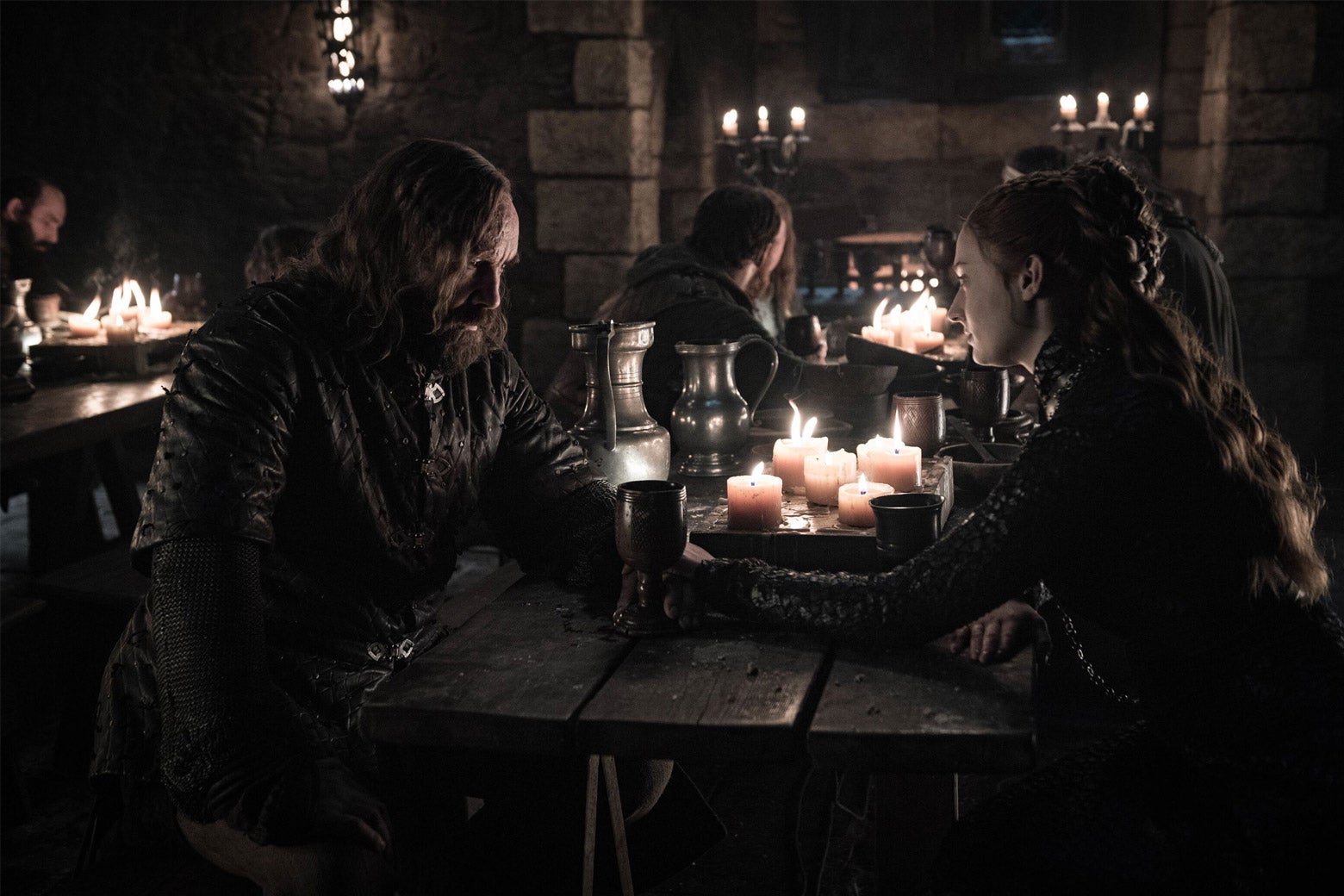 The Hound and Sansa sit across from each other at a table.