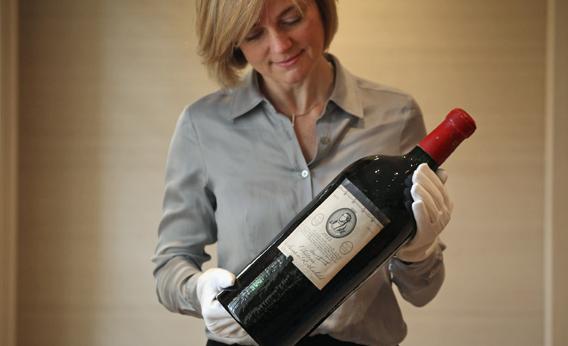 An employee of Sotheby's auction house holds a rare Jeroboam of Chateau Mouton Rothschild from 1953 on Jan. 17, 2012 in London