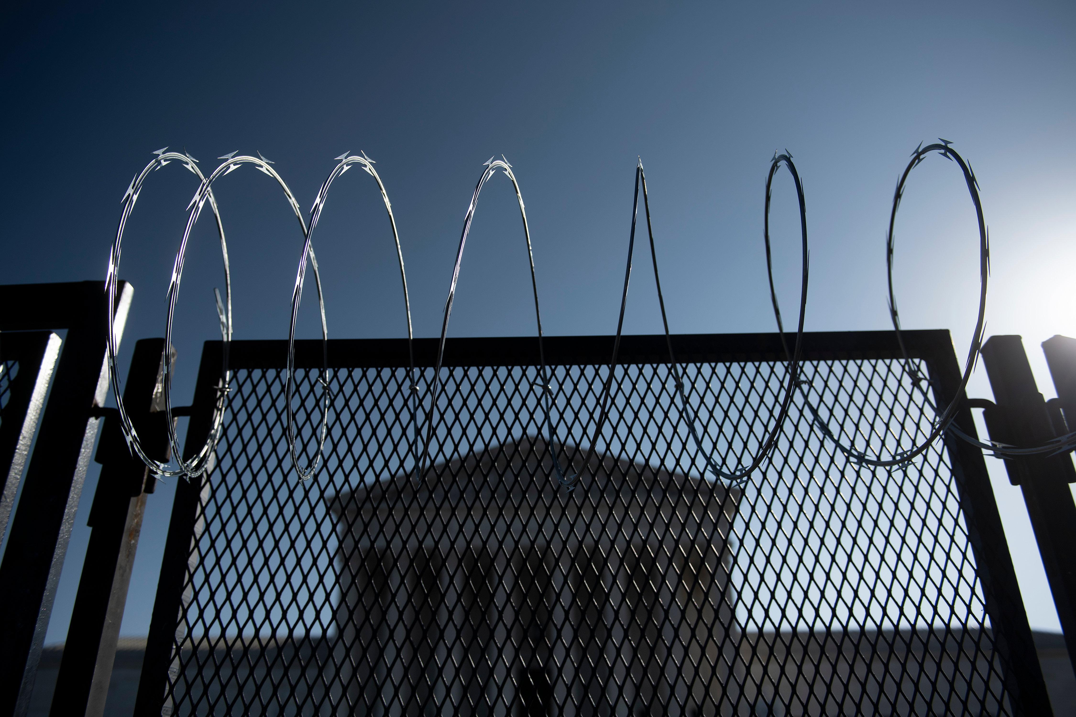 The Supreme Court surrounded by a fence and barbed wire.