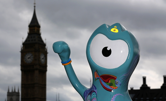 People sit next to a model of a Wenlock, one of the official 2012 Olympic mascots on July 17, 2012 in London, England.