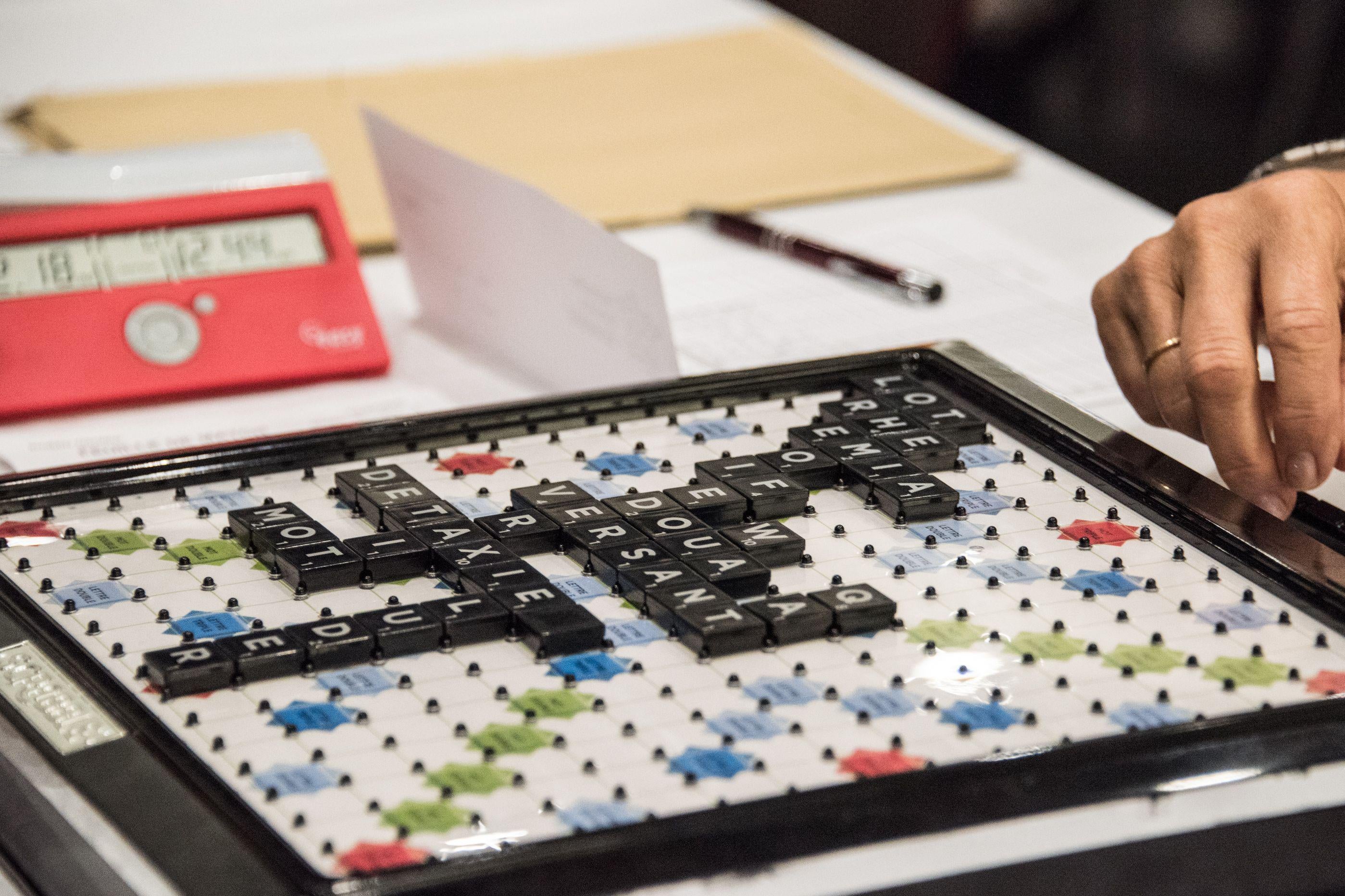Scrabble players choose a word during the World Scrabble Championships on August 29, 2016 at the Grand Palais in Lille.