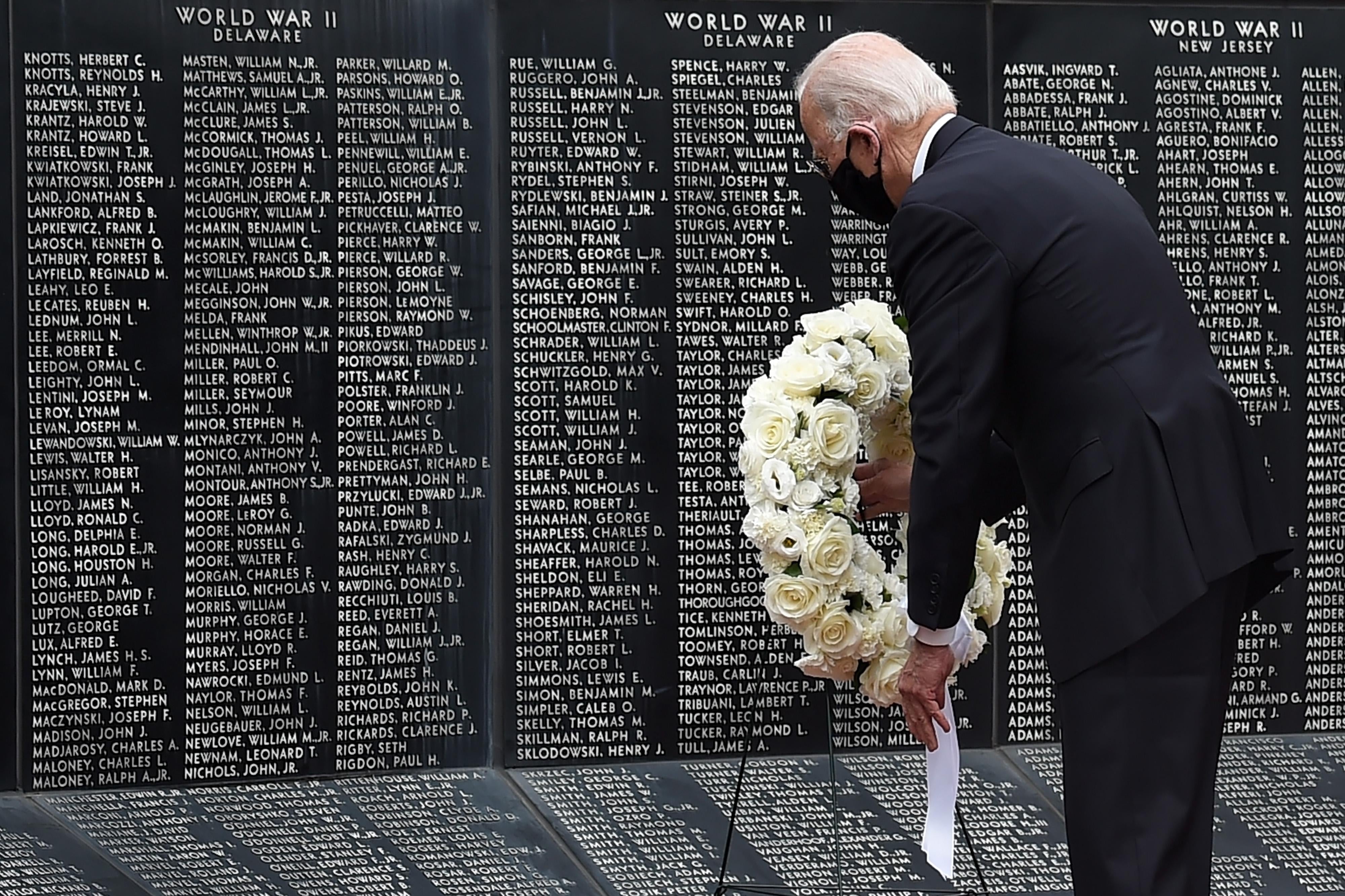 Democratic presidential candidate Joe Biden, wearing a black mask, lays a wreath to pay his respects to fallen service members on Memorial Day.