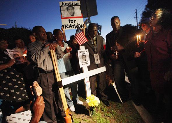 Supporters gather around a cross during a candlelight vigil at a memorial to Trayvon Martin in Sanford, Fla., on March 25, 2012. 