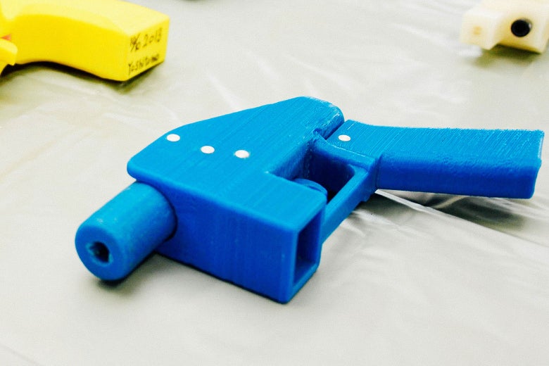 A blue plastic handgun with yellow plastic handguns off to the side.