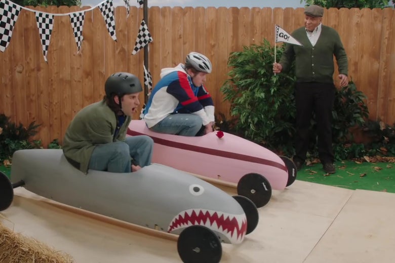 Kyle Mooney and Beck Bennett riding downhill derby racers.
