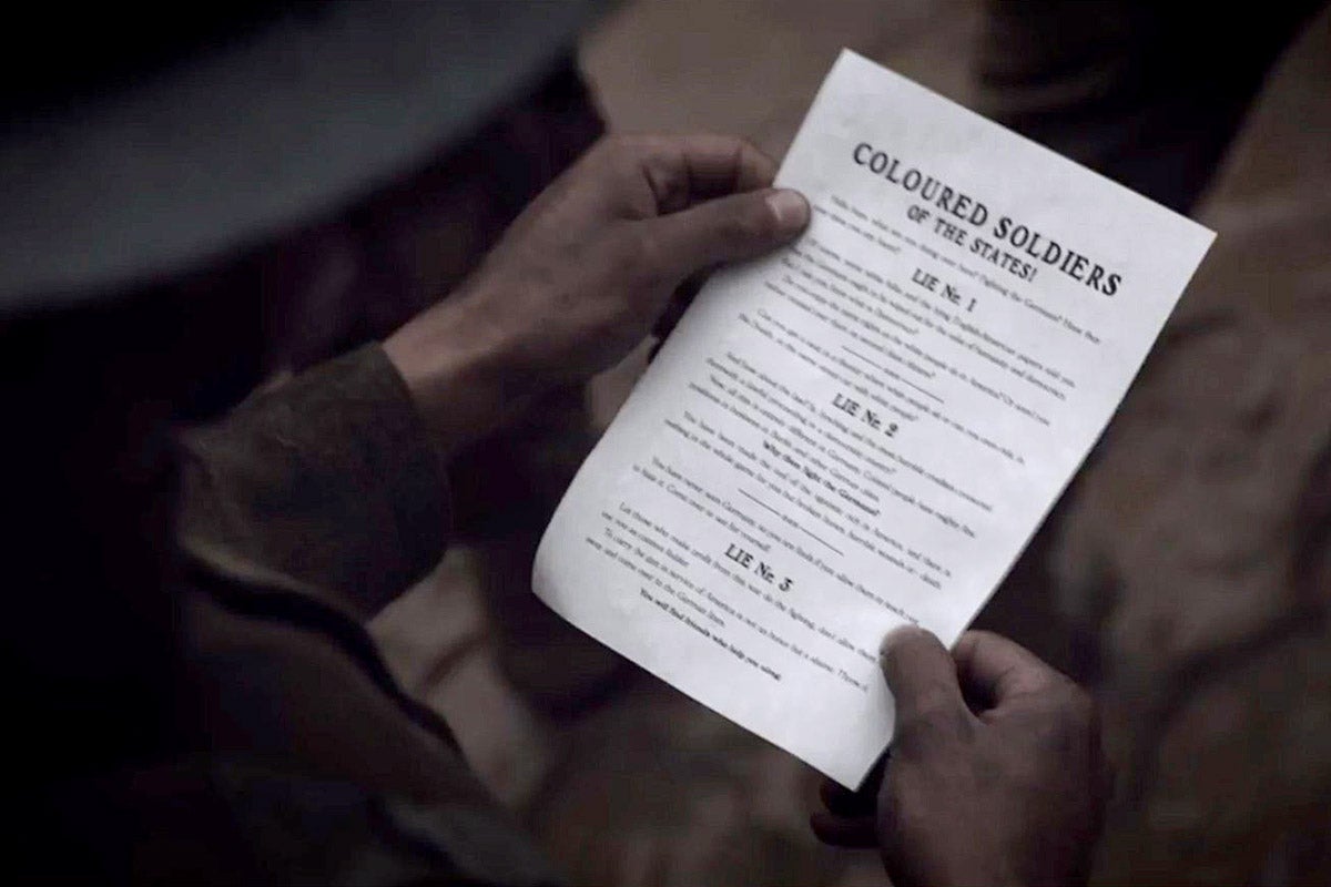 A black soldier holding a WWI leaflet.