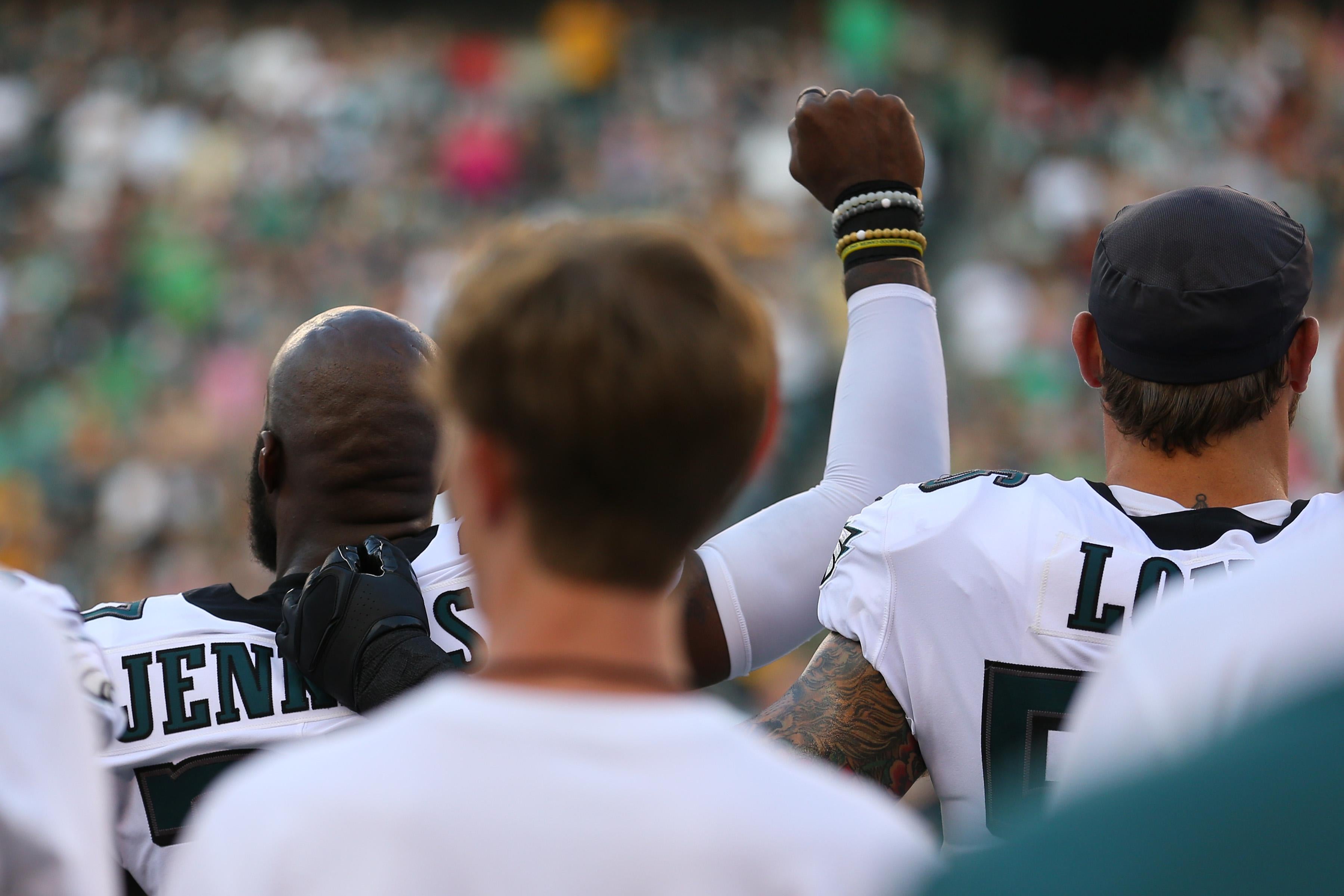 Malcolm Jenkins #27 of the Philadelphia Eagles raises his fist during the national anthem as Chris Long #56 puts his arm around him
