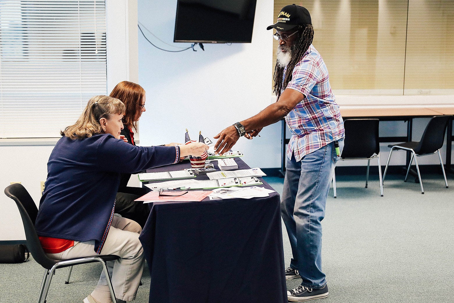 Voter registration workers Rosey Brockamp and Sheryl Podley register Clarence Singleton on Jan. 8 in Fort Myers, Florida.