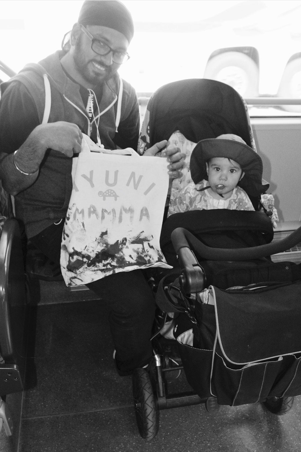 This father, himself a bus driver, commutes home on the bus with his daughter after picking her up from day care (dagis). Parents with strollers ride public buses for free in Stockholm. He proudly holds up an art project she made that day for her mother. 