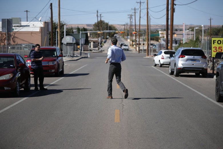 O'Rourke jogs across a two-lane road to greet a voter.