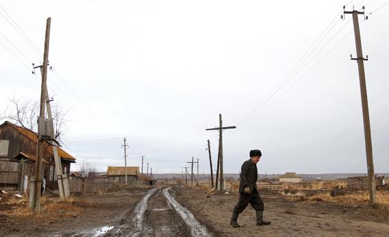 A man walks next to his old house in the village of Muslyumovo November 17, 2010. The village is located on the banks of the Techa river in Russia's Urals, one of the country's most lethal nuclear dumping grounds. 