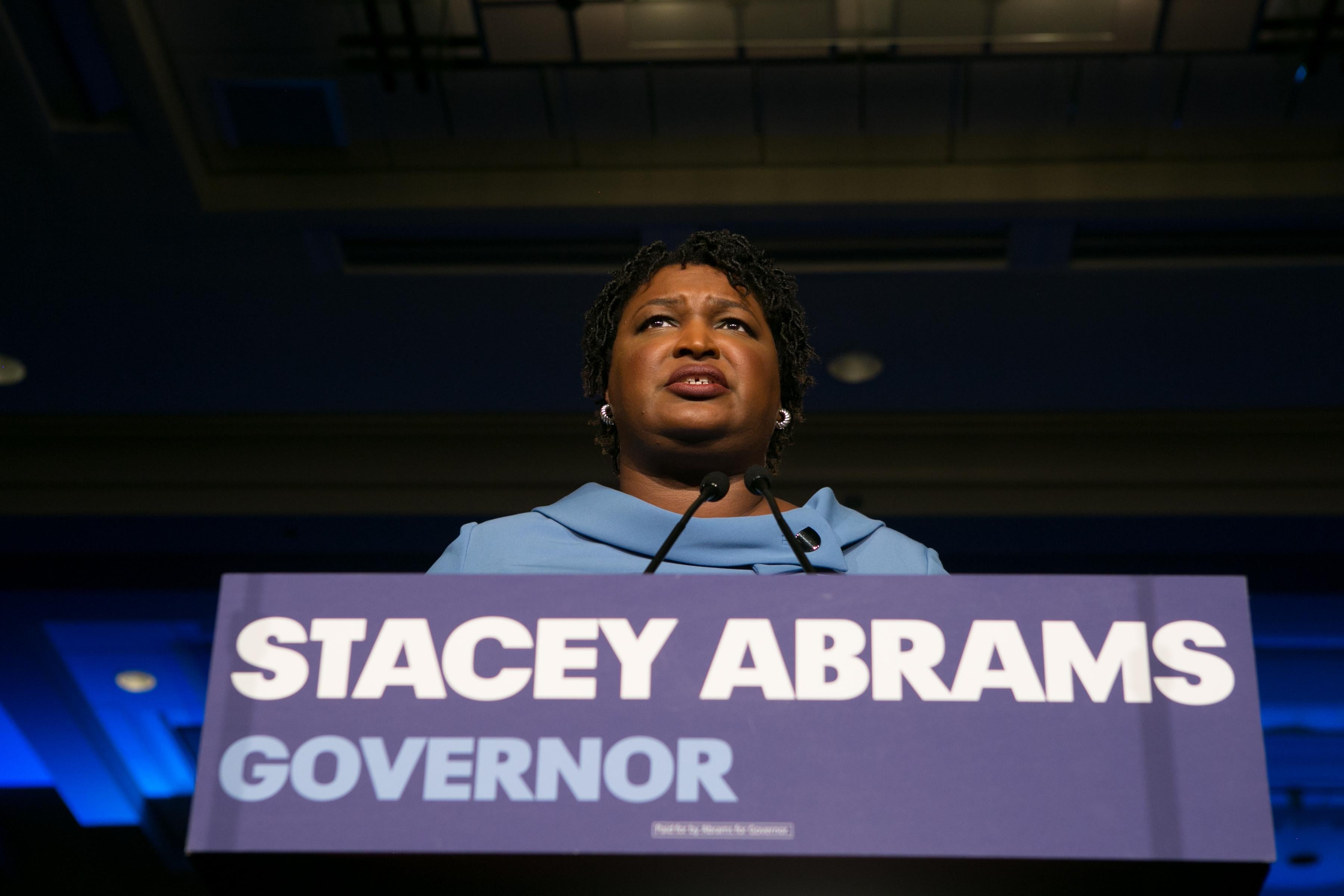 Stacey Abrams speaking behind a podium at an election event November 6.