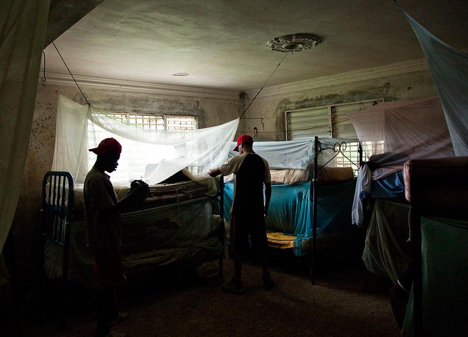 BOCA CHICA, DOMINICAN REPUBLIC. Players live in abandoned houses where they train all day with other prospects. Mosquito nets cover rotten mattresses in this training camp. Players hope to sign with a professional team after they turn 16.5.