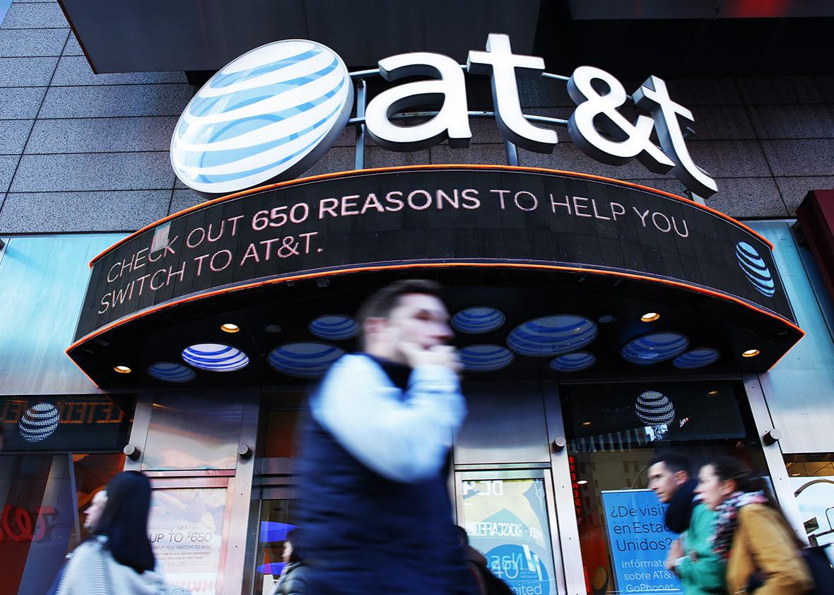 People walk past an AT&T store in New York on October 23, 2016. 