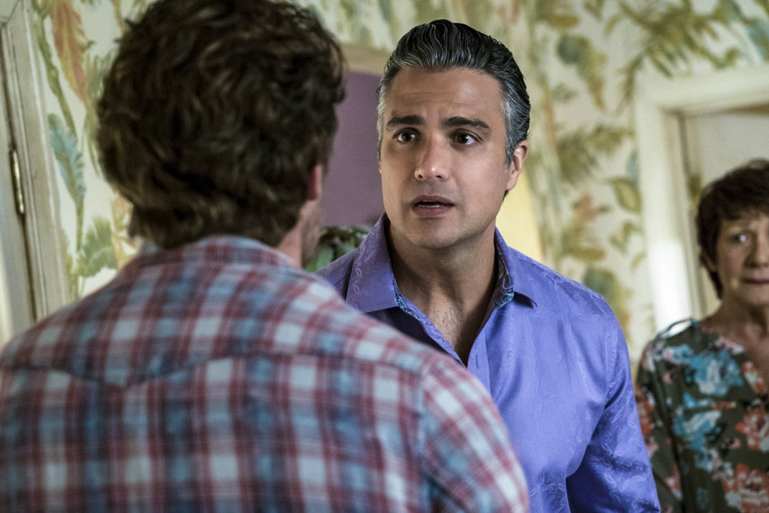 In a still from Jane the Virgin, Rogelio and Alba look upset, facing Jason.