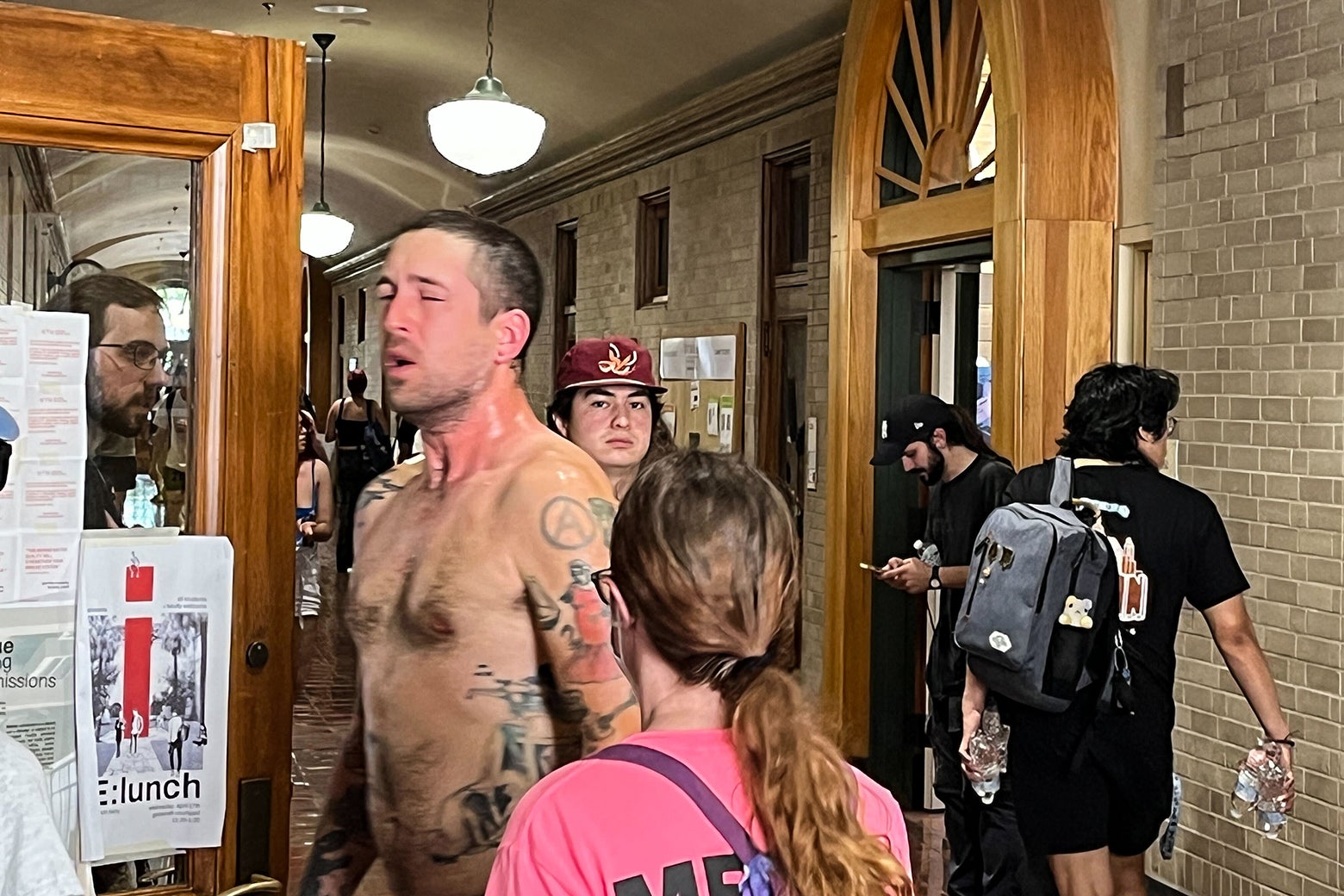 A shirtless man recovers pepper spray. 