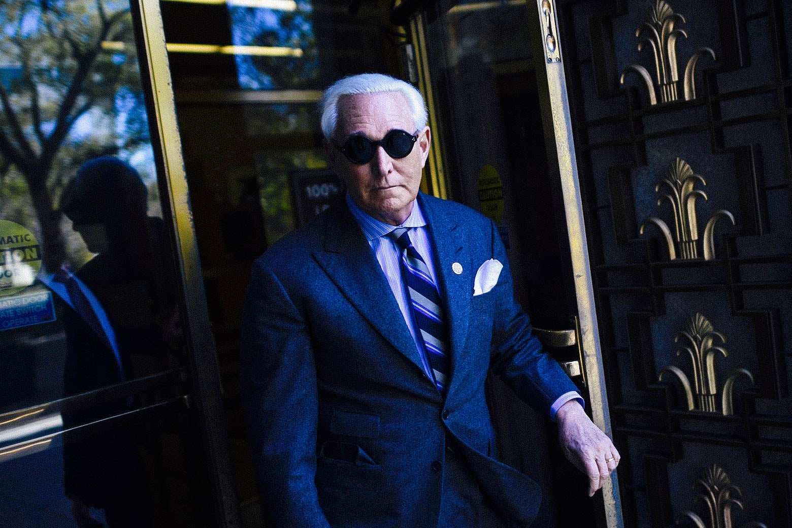 Roger Stone in sunglasses, leaving a courthouse.