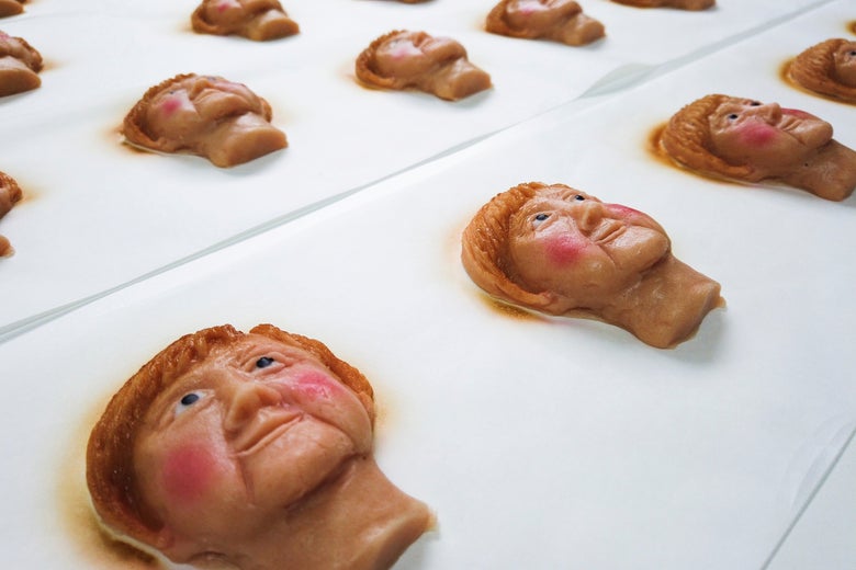 Cookies portraying Angela Merkel's face are seen on a sheet.