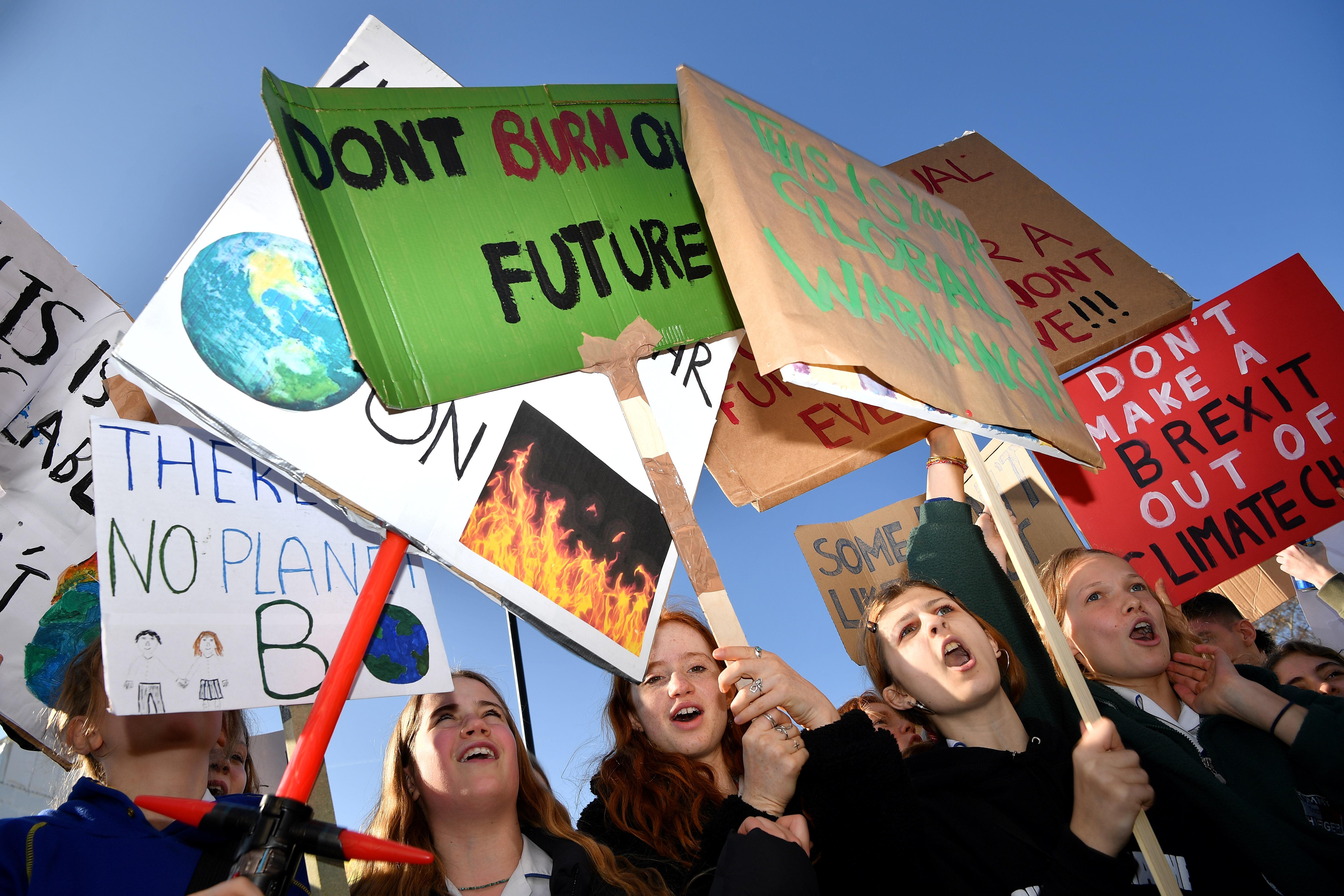 Young demonstrators hold placards as they attend a climate change protest organised by 'Youth Strike 4 Climate', opposite the Houses of Parliament in central London on February 15, 2019. - Hundreds of schoolchildren went on 'strike' on Friday to take over London's Parliament Square in a protest against climate change. Children of all ages chanted 'save our planet', cheered as flares were lit and clambered onto statues in the shadow of Big Ben to call for action, and to raise awareness of the issue. (Photo by Ben STANSALL / AFP)        (Photo credit should read BEN STANSALL/AFP/Getty Images)