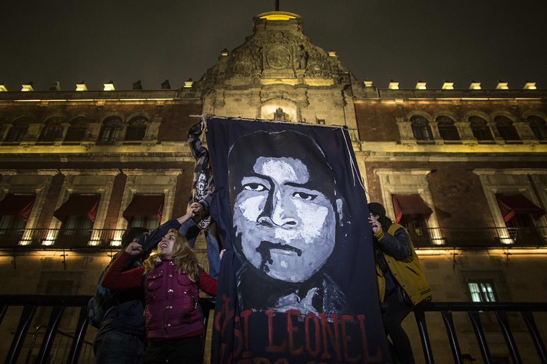 Demonstrators hold a sign with the face of one of the missing students during a spontaneous demonstration on November 8. 