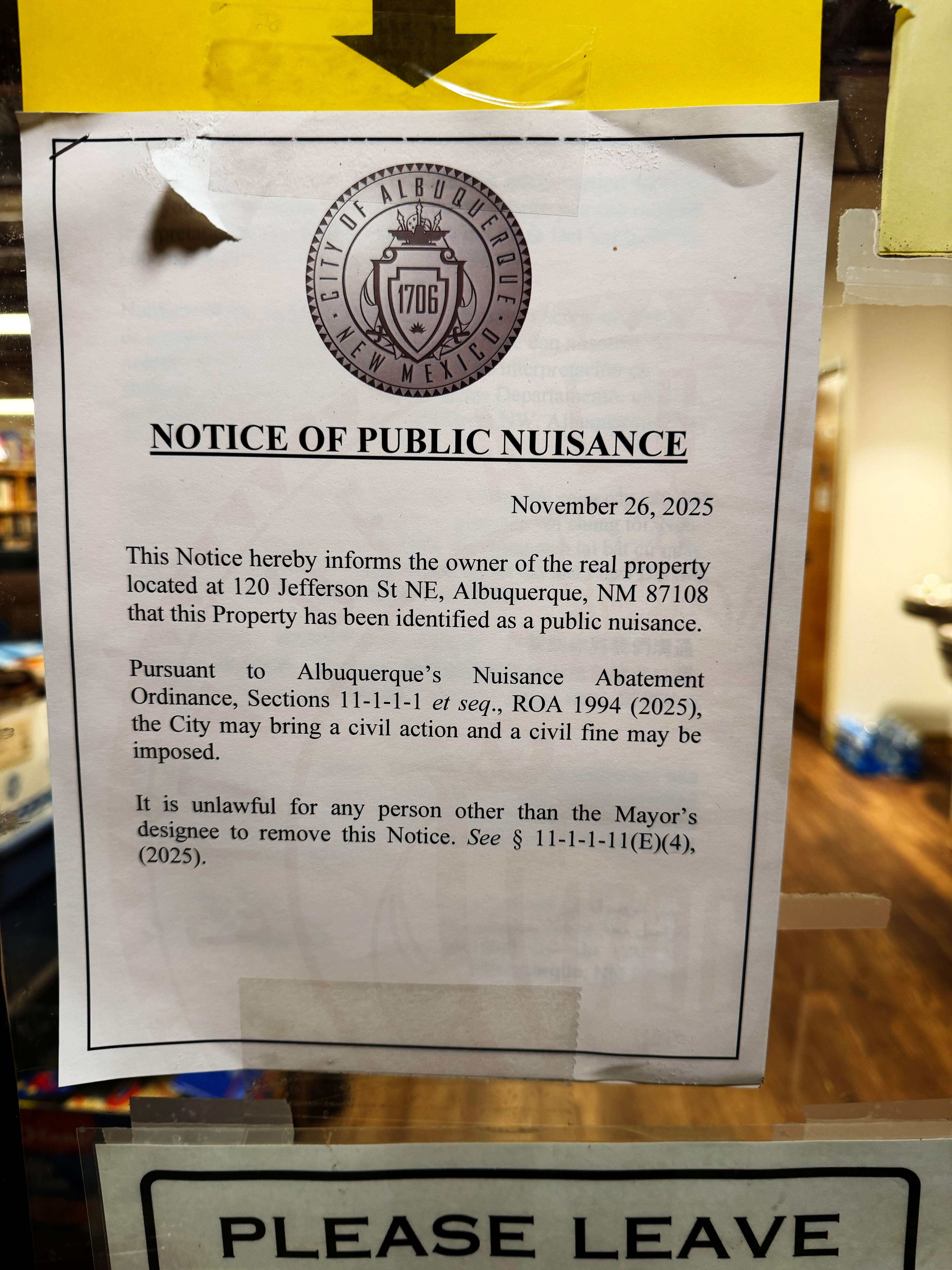 Notice of Public Nuisance is posted on a glass door. 
