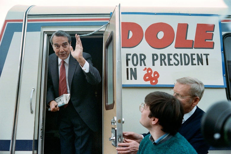 Republican presidential candidate Robert Dole waves as he boards his campaign's mini-bus on February 3, 1988 after finishing a stump speech in Belmond, small northern Iowa Town. 