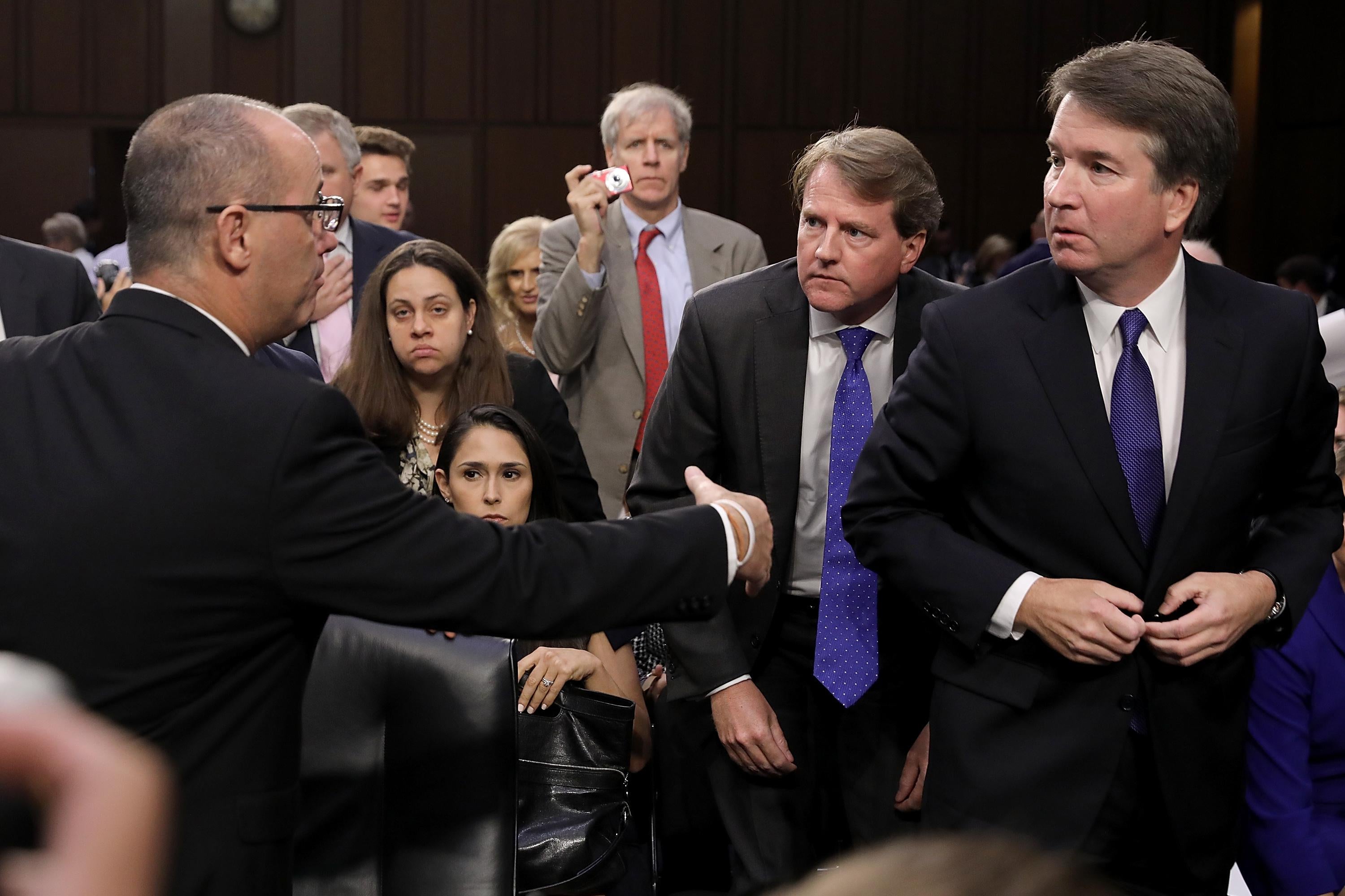 Fred Guttenberg extends his hand to Supreme Court nominee Brett Kavanaugh, who looks concerned. 