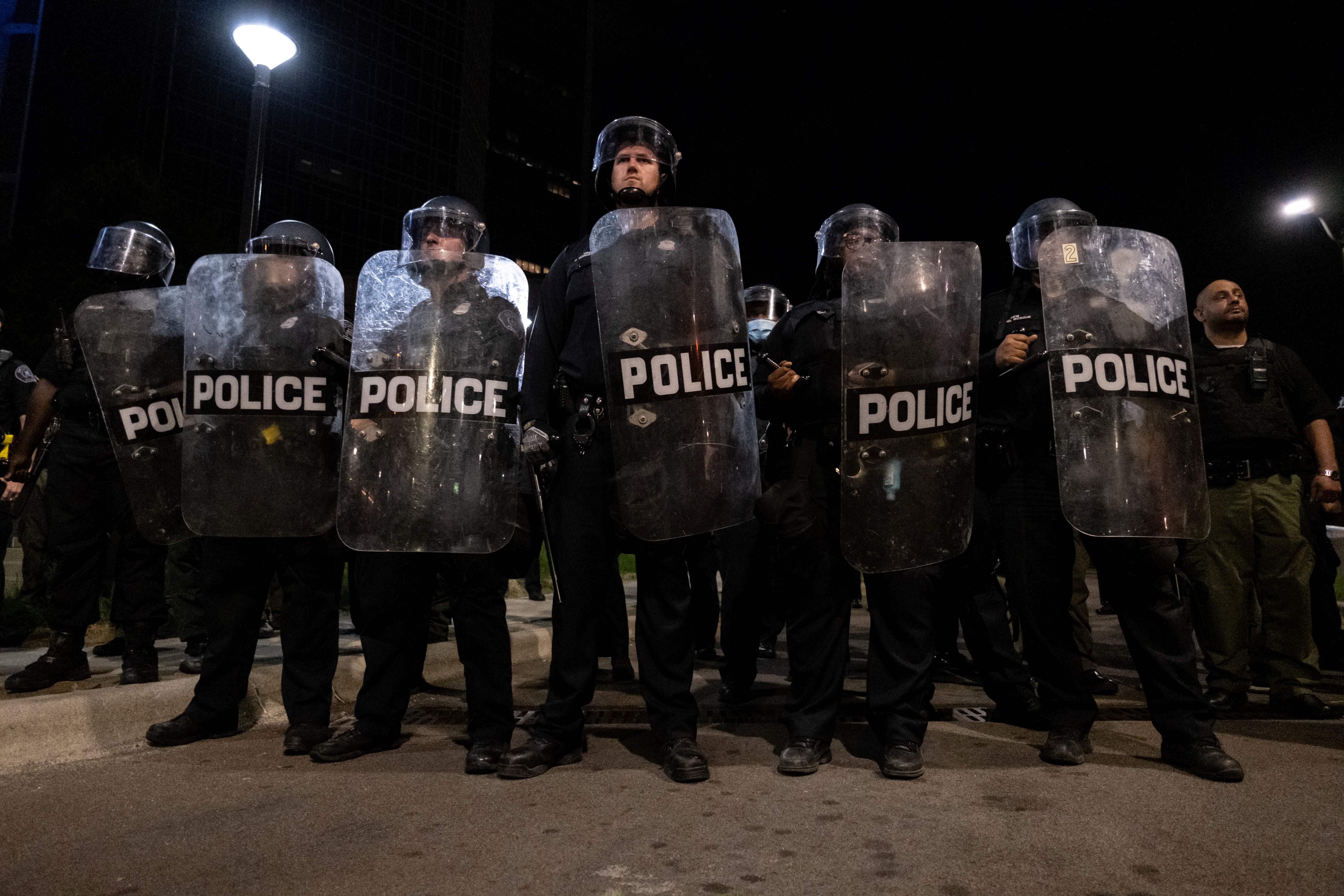 Police officers holding shields.