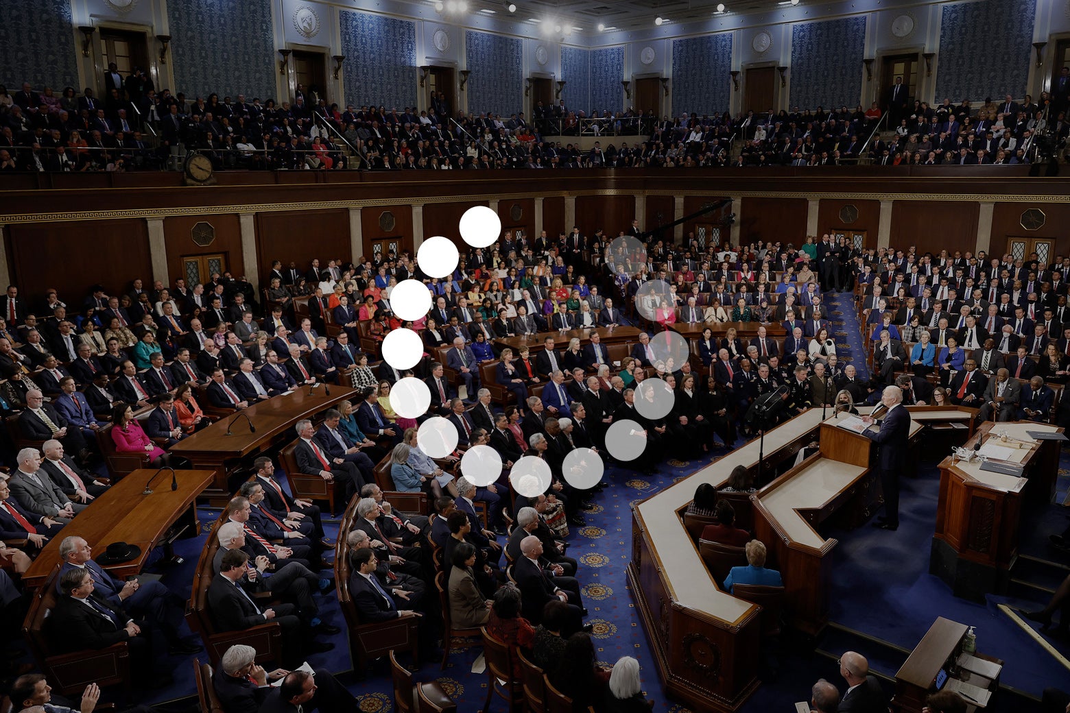 An photo of Congress full of members, listening to Pres. Joe Biden's State of the Union address. The photo is overlaid with the circular icon that appears when you reboot a device. 