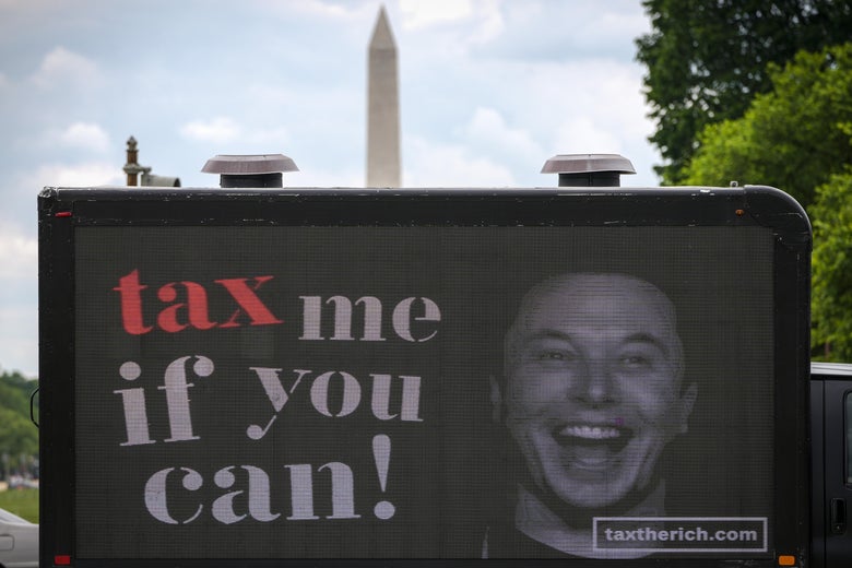 A mobile billboard outside the U.S. Capitol featuring Elon Musk grinning beside the words "Tax Me if You Can!"