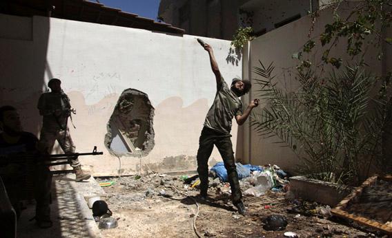 A Free Syrian Army fighter throws a homemade bomb towards forces loyal to Syria's President Bashar al-Assad as fellow fighters watch in Deir al-Zor July 14, 2013.