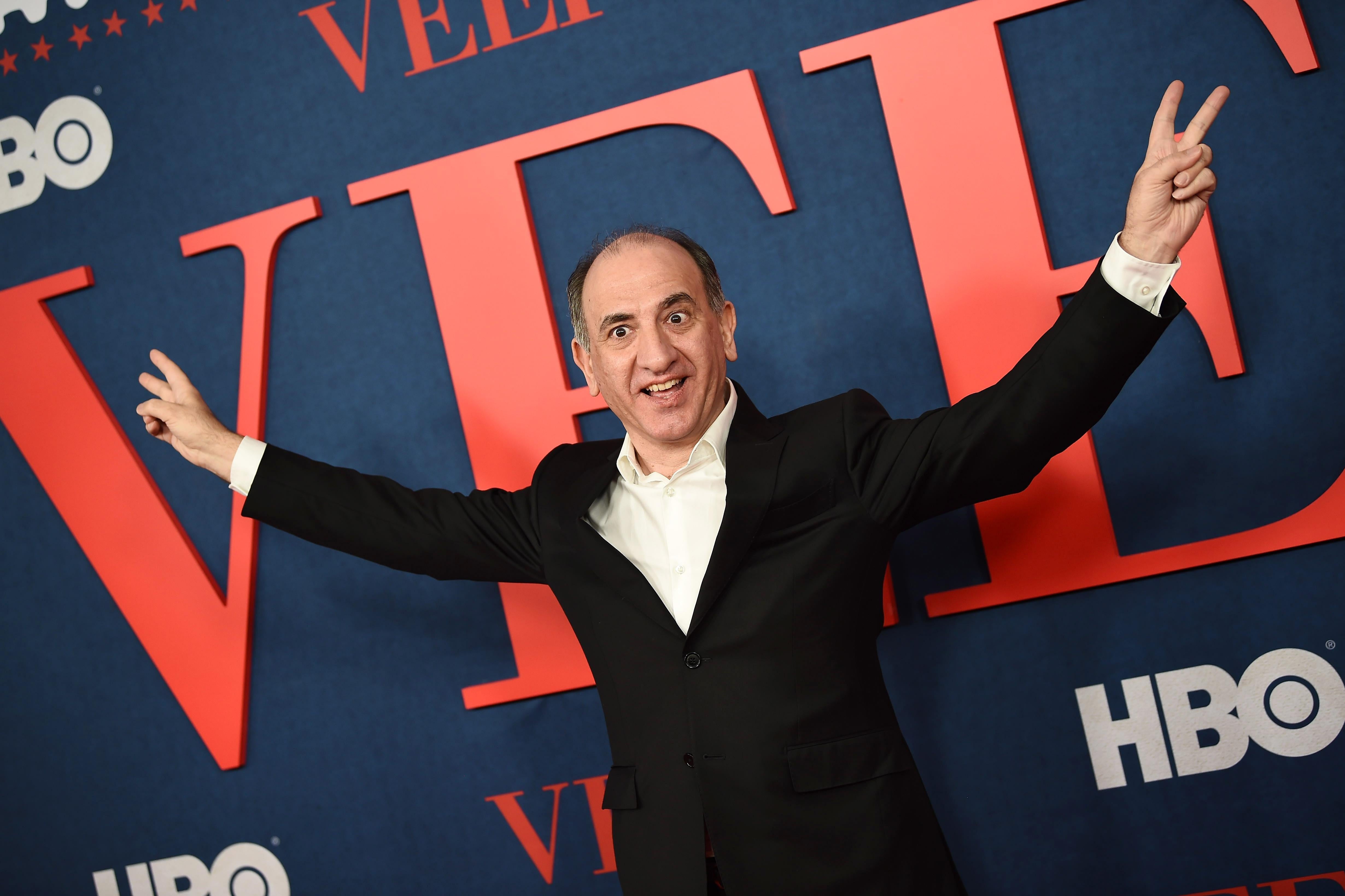 Armando Iannucci, making the Nixon victory gesture, on a red carpet.