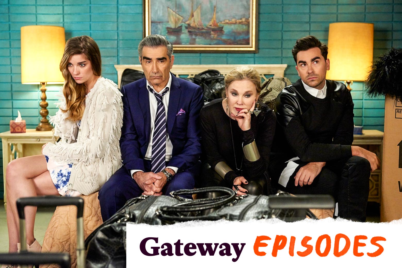 Annie Murphy, Eugene Levy, Catherine O'Hara, and Dan Levy sit on a motel bed in this still from Schitt's Creek.