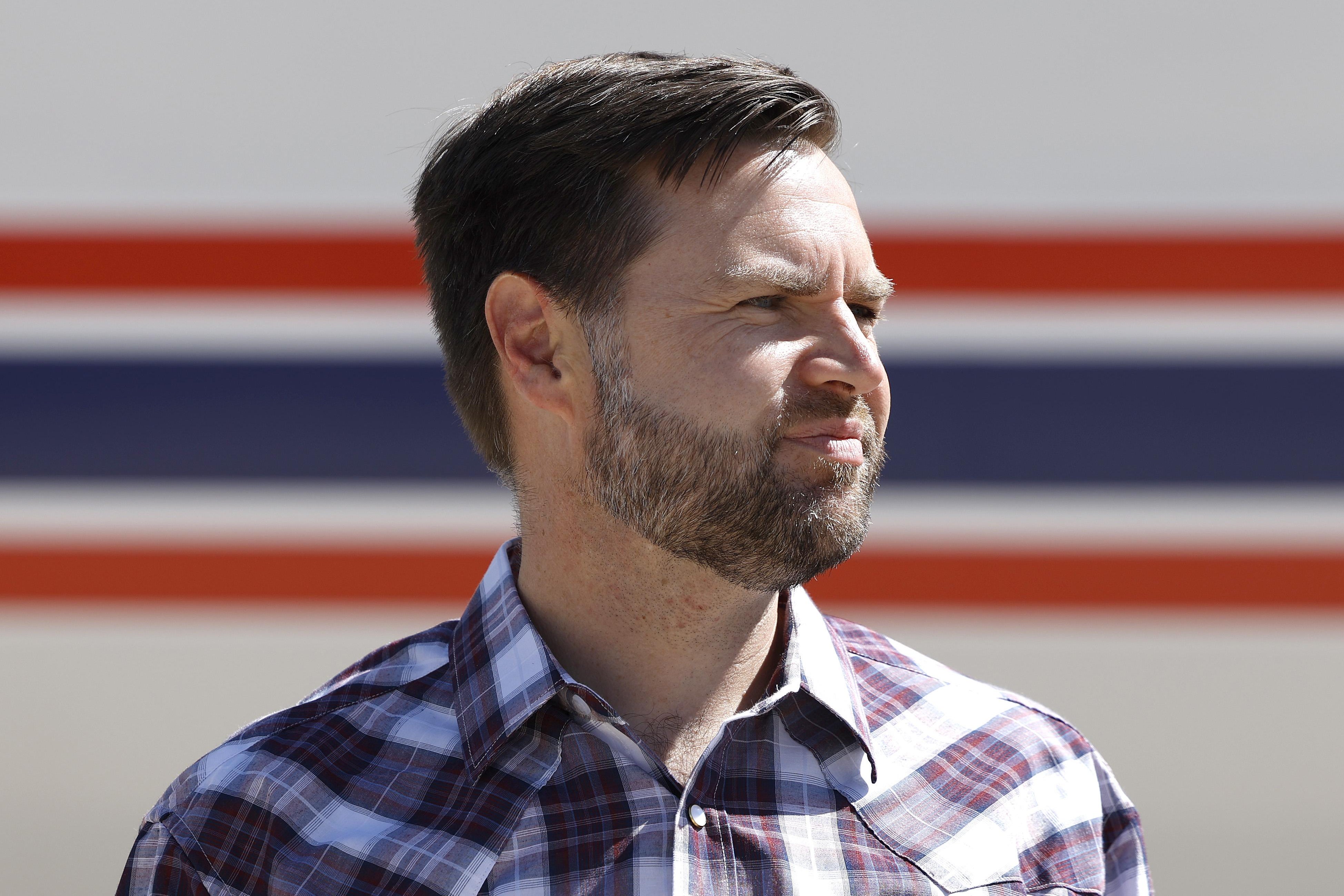 J.D. Vance in front of his red-white-and-blue-striped plane.