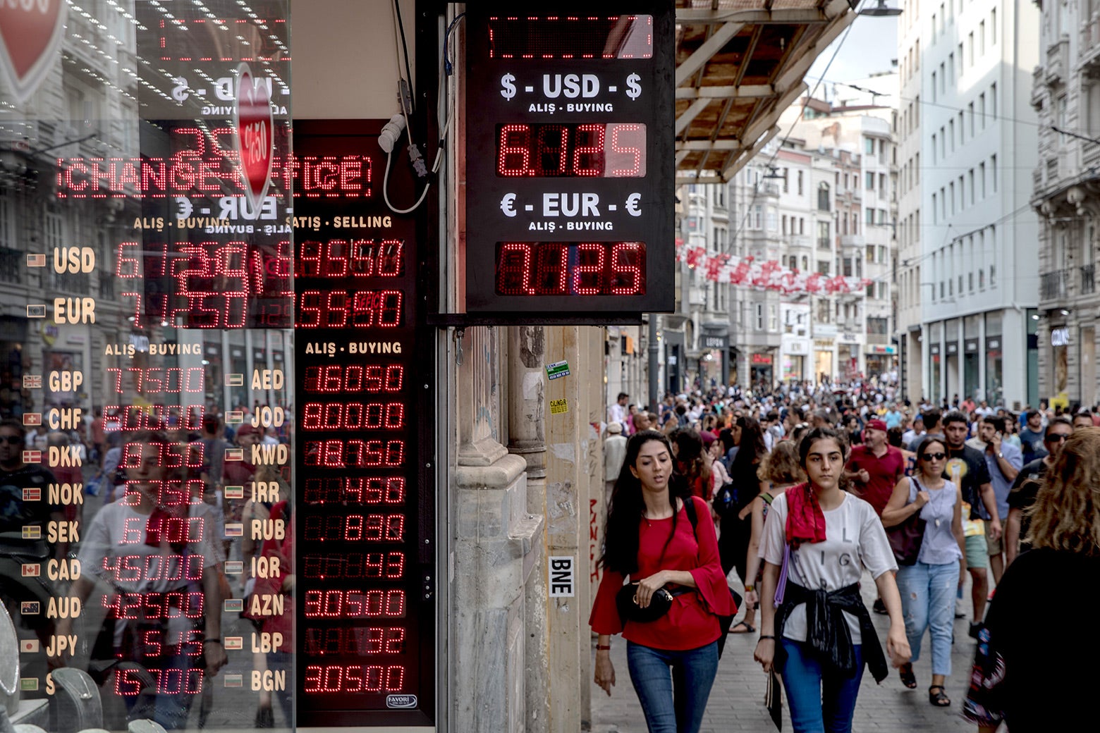 People walk past a currency exchange office on Aug. 29 in Istanbul.