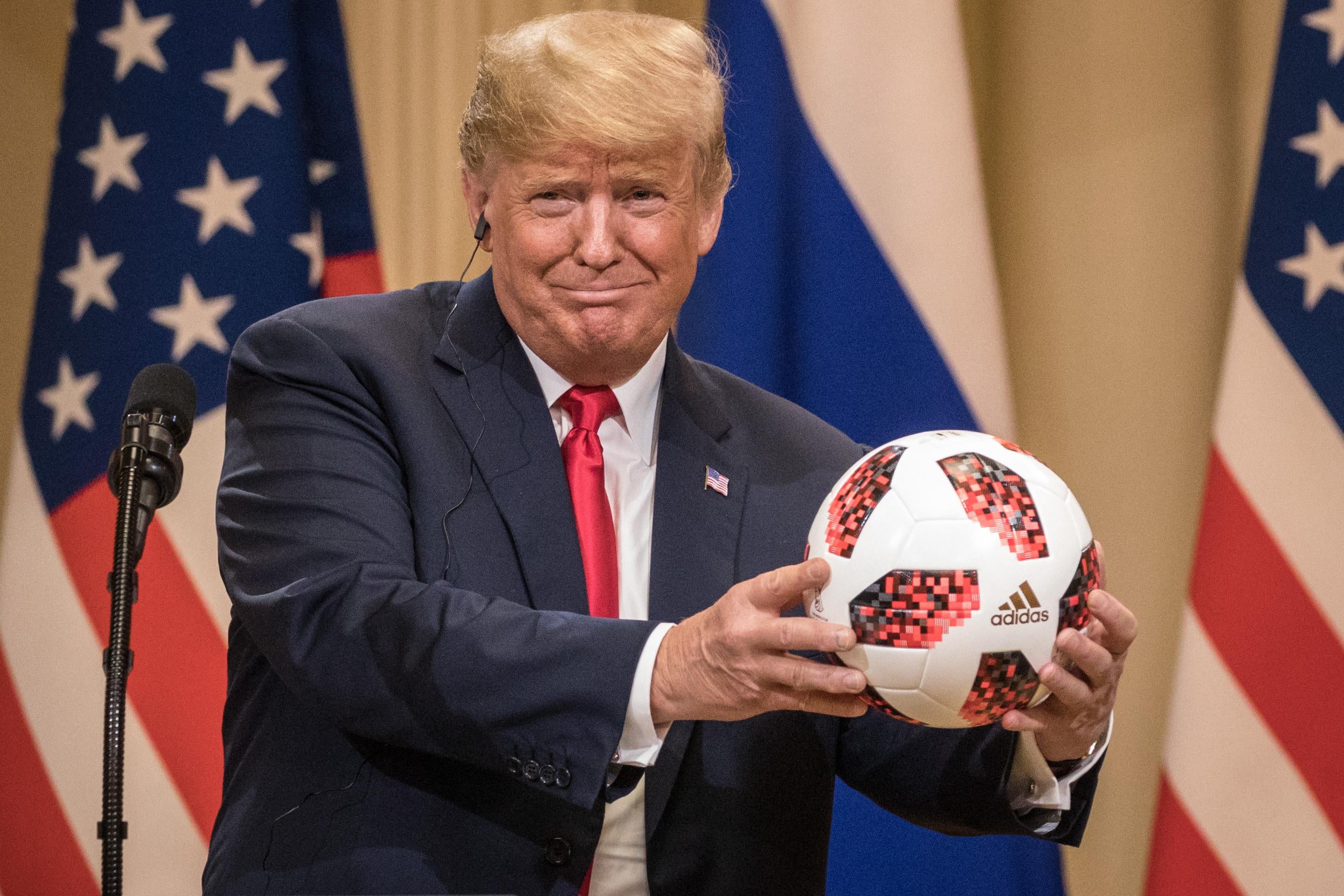 President Donald Trump holds a World Cup football given to him by Russian President Vladimir Putin during a joint press conference after their summit on July 16, 2018 in Helsinki, Finland. 