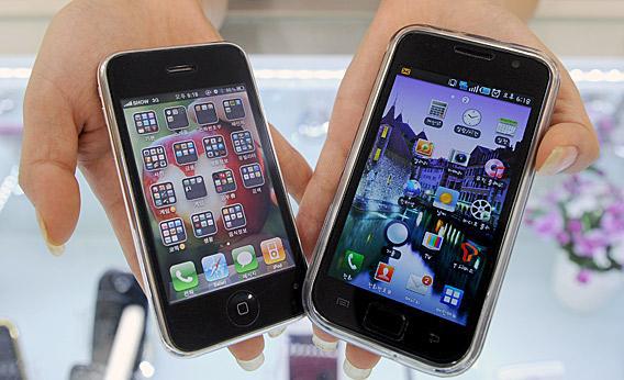 South Korea shop manager shows Samsung Electronics' Galaxy S mobile phone (R) and Apple's iPhone 3G at a shop in Seoul