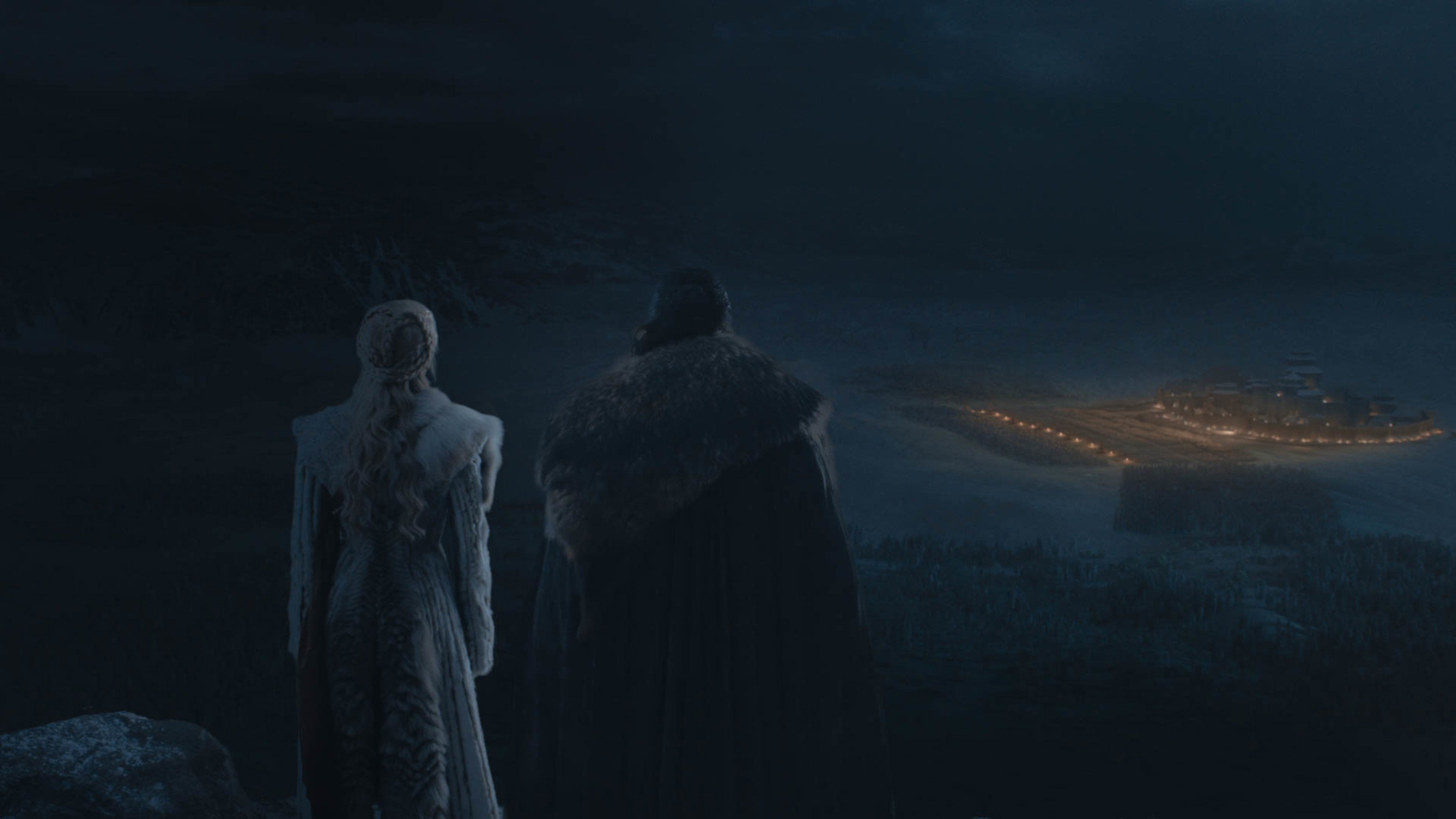 Daenerys and Jon Snow looking across a dark battlefield.