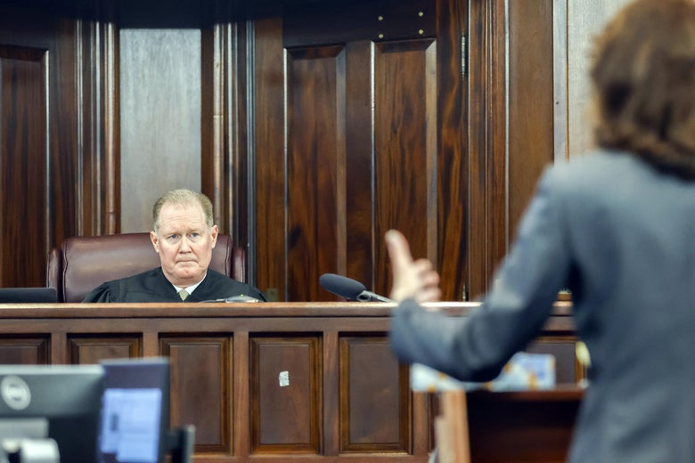 Superior Court Judge Timothy Walmsley, left, listens to prosecutor Linda Dunikoski's opening statement during the sentencing of Greg McMichael and his son, Travis McMichael, and a neighbor, William "Roddie" Bryan in the Glynn County Courthouse, on January 7, 2022 in Brunswick, Georgia. 