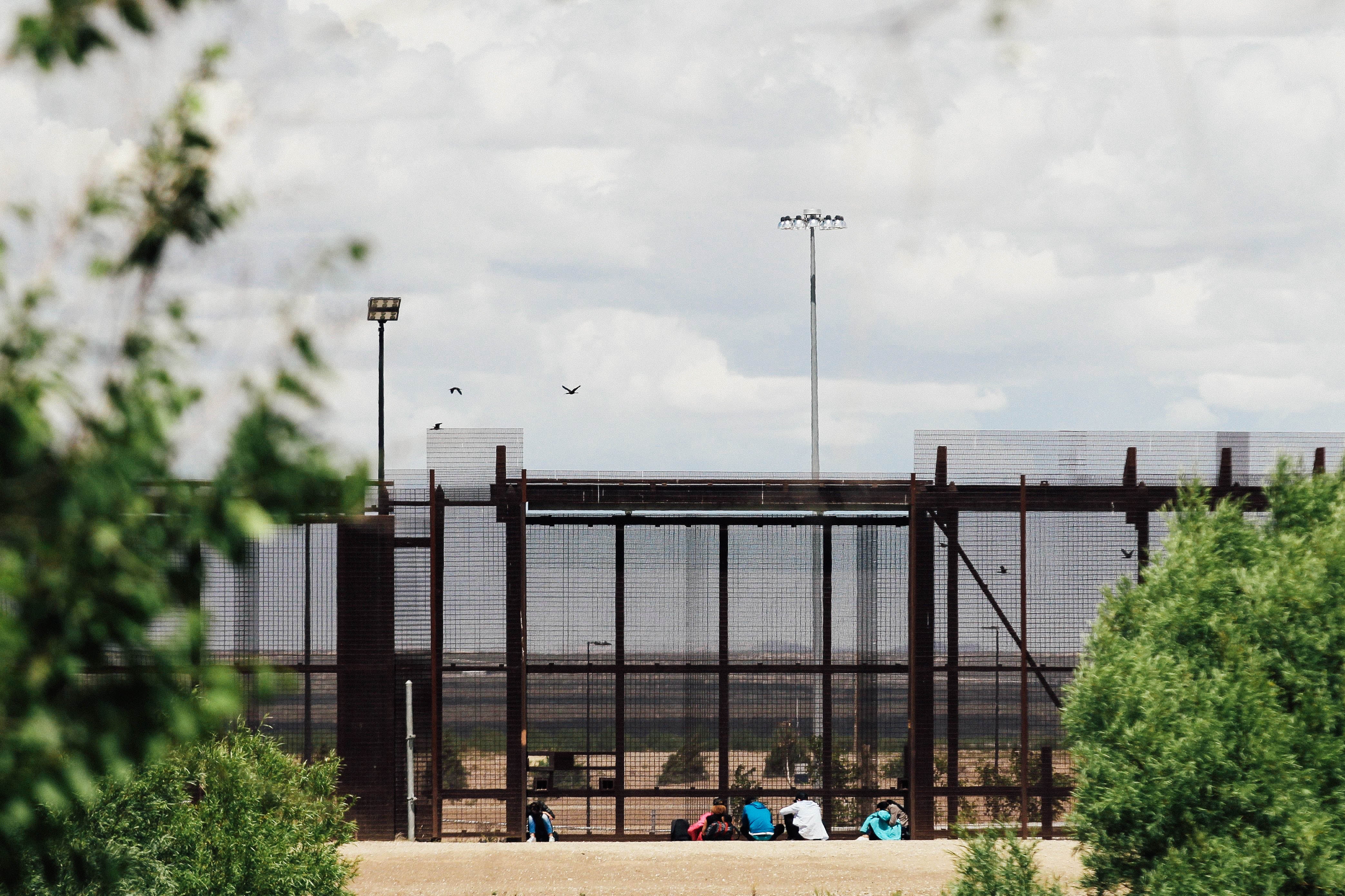 A group of migrants wait to be stopped by the Border Patrol at the border wall in El Paso, Texas as seen from Ciudad Juarez, Mexico on Wednesday.