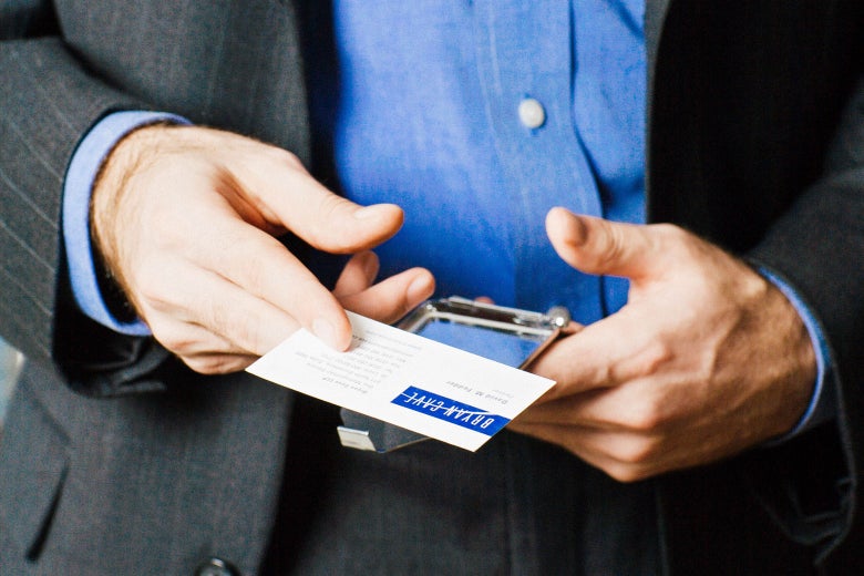 Stock image of a man holding out a business card.