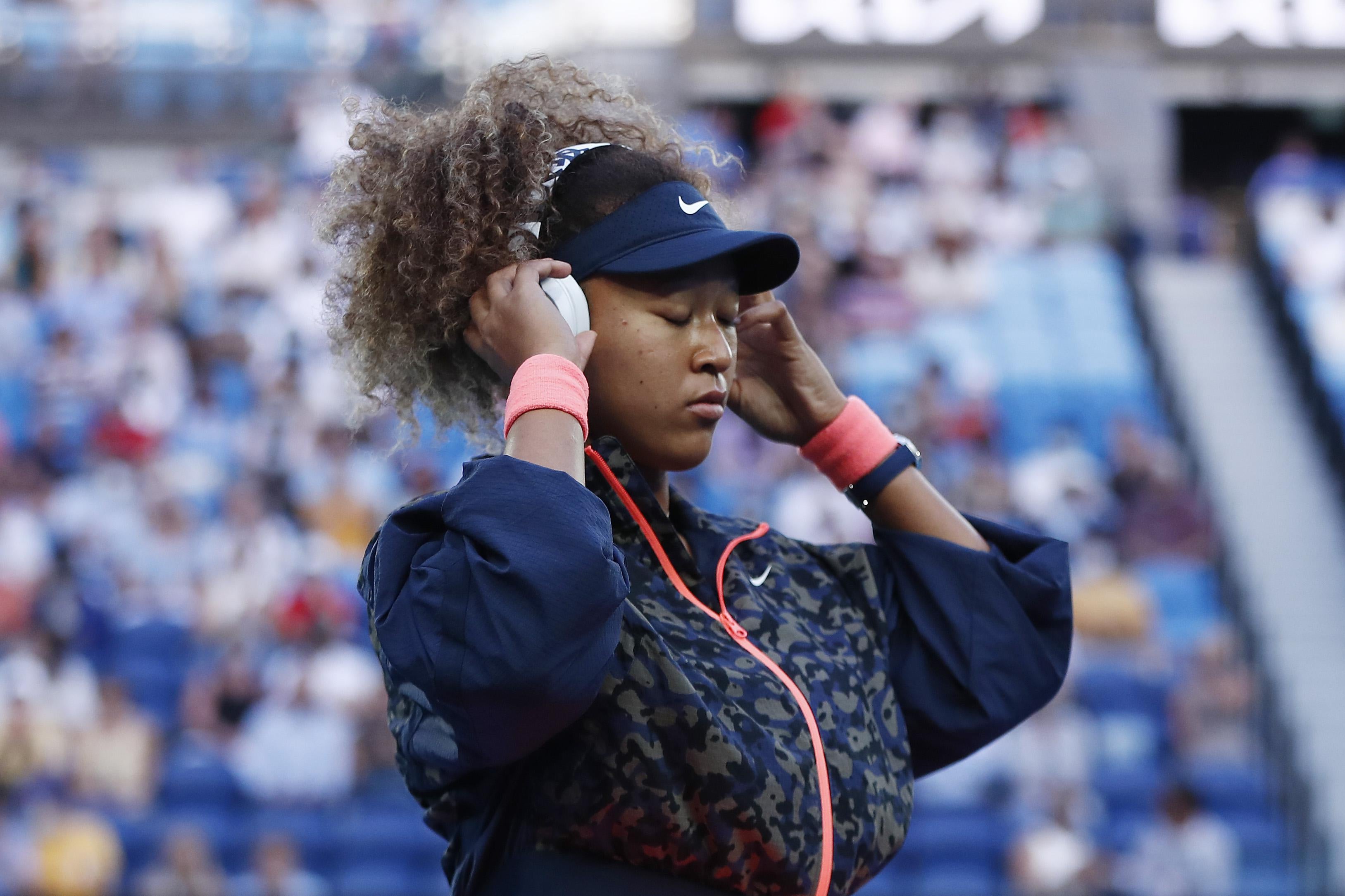 Naomi Osaka of Japan adjusts her headphones prior to her Women’s Singles Final match against Jennifer Brady of the United States during day 13 of the 2021 Australian Open at Melbourne Park on February 20, 2021 in Melbourne, Australia.